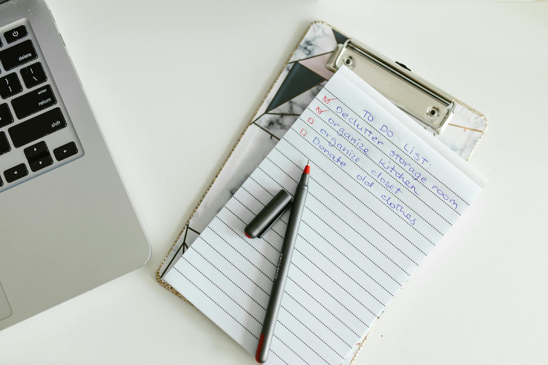 Lista zadań ślubnych na clipboardzie obok laptopa i długopisu