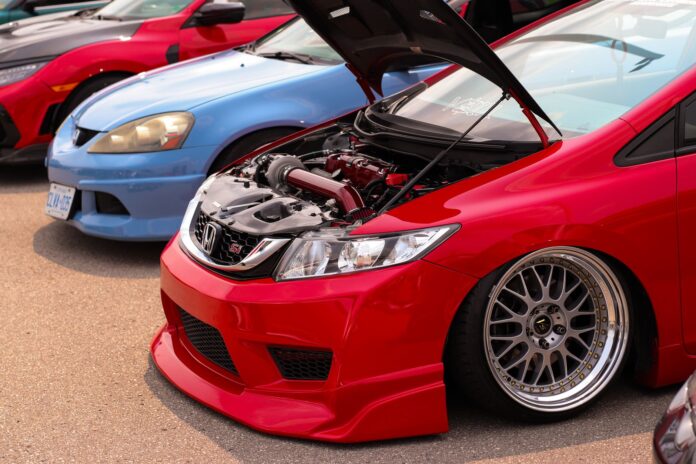 Dwa auta Honda z otwartą maską prezentujące zmodyfikowane silniki