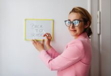 Pilotaż innowacji regionalnej w szkole: checklista przed pierwszymi zajęciami Nauczycielka w różowej marynarce pisze na tablicy Back to School