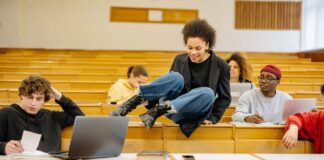 Różnorodni studenci rozmawiają i uczą się w sali wykładowej