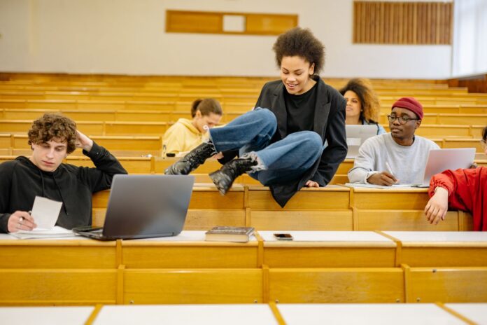 Różnorodni studenci rozmawiają i uczą się w sali wykładowej