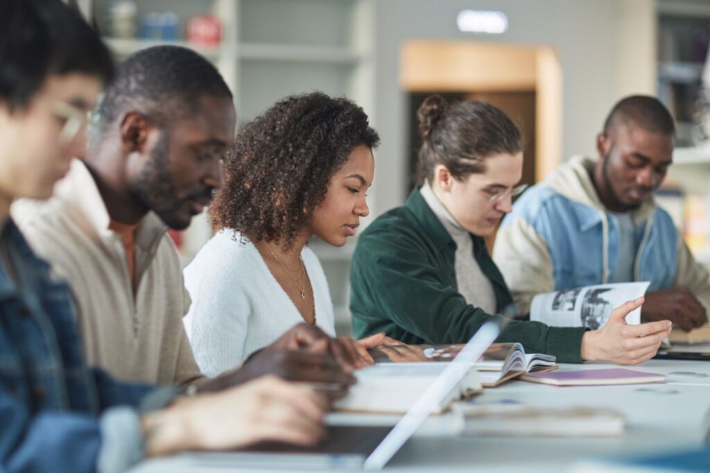 Wielokulturowa grupa studentów ucząca się razem w bibliotece